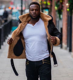 Interior view of Jean's B3 Bomber Aviator Shearling Jacket with hoodie, showing plush tan shearling lining on black leather, worn by a man on a city street.