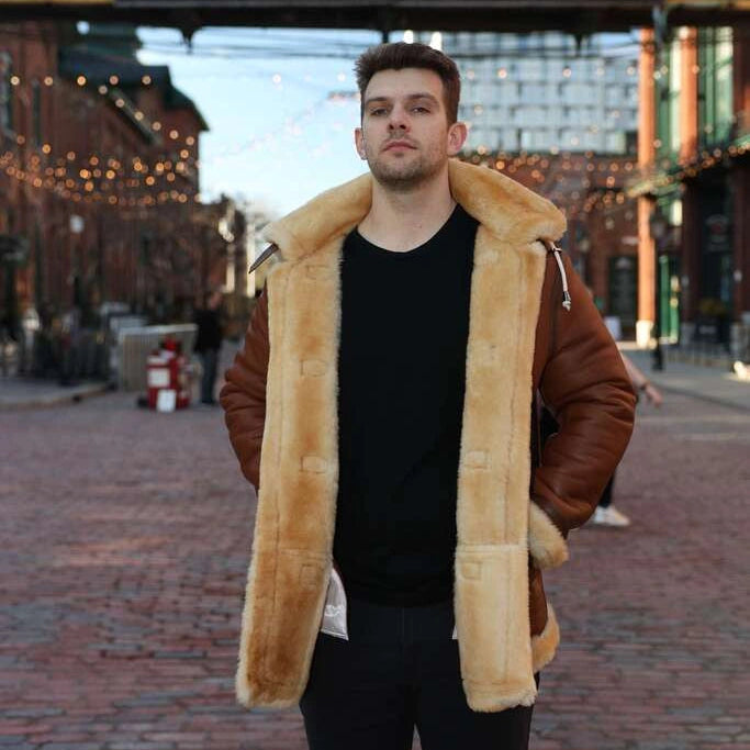 Man wearing a brown shearling coat standing in front of Gooderham & Worts Limited building.