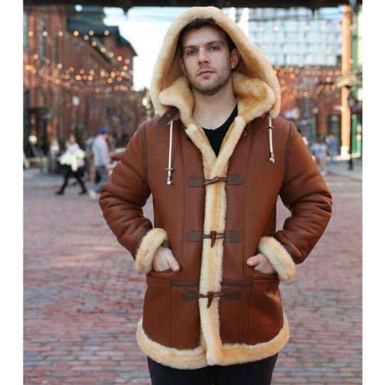 Person wearing a brown leather coat with fur trim in an urban setting.