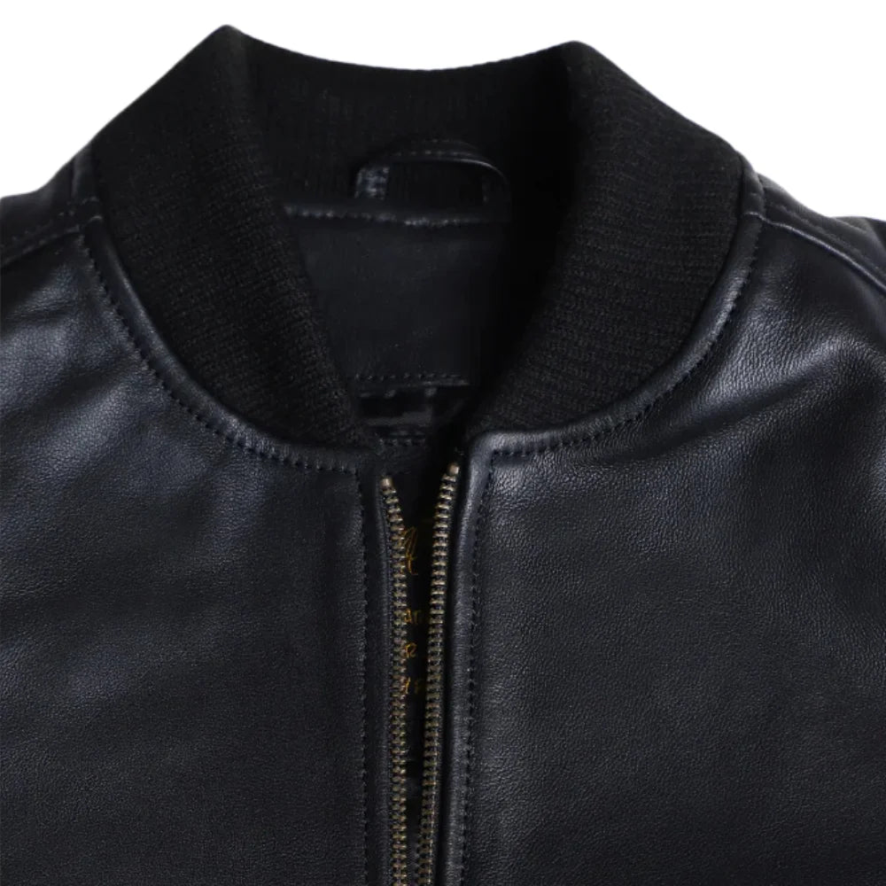 Close-up of the Mabel jacket’s smooth black leather texture, highlighting the ribbed cuffs and deep slanted side pockets.
