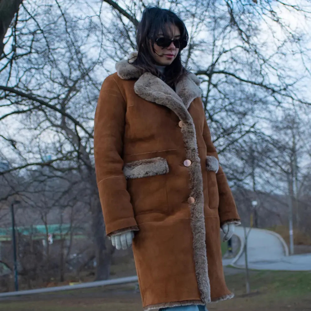 Close-up detail of the Sabina coat’s tobacco-colored full-grain leather and thick, cream-colored shearling lining.