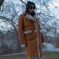 Close-up detail of the Sabina coat’s tobacco-colored full-grain leather and thick, cream-colored shearling lining.