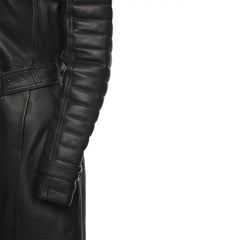 Close-up of a black leather trench coat with quilted sleeves on a white background
