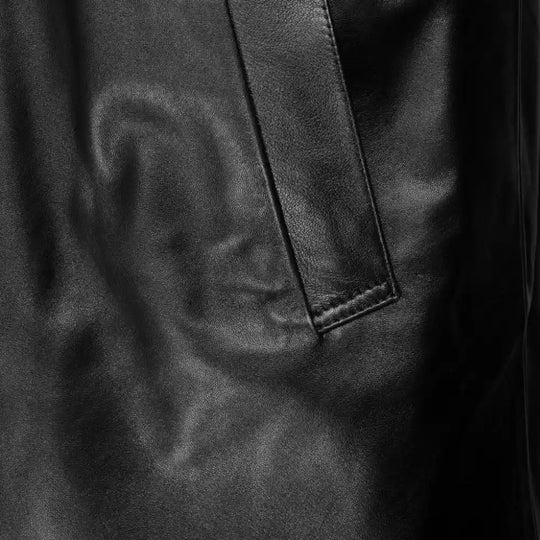 Close-up of a textured black leather surface with a pocket detail.