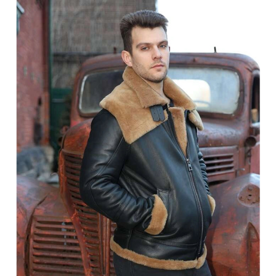 Man wearing Graysen black Aviator bomber shearling jacket with brown fur lining standing in front of an old rusted truck.