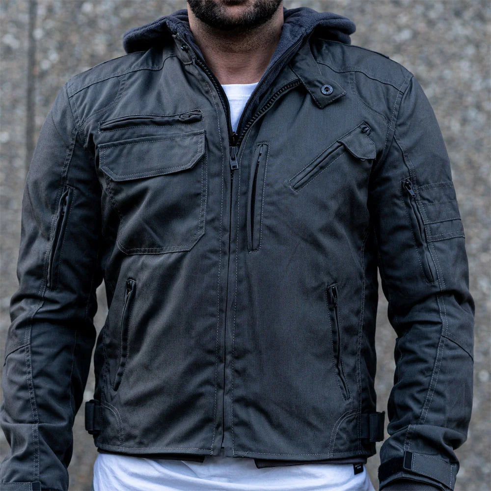 A model on a motorcycle wearing the grey hooded jacket, demonstrating the relaxed urban fit and the airflow functionality of the vents.