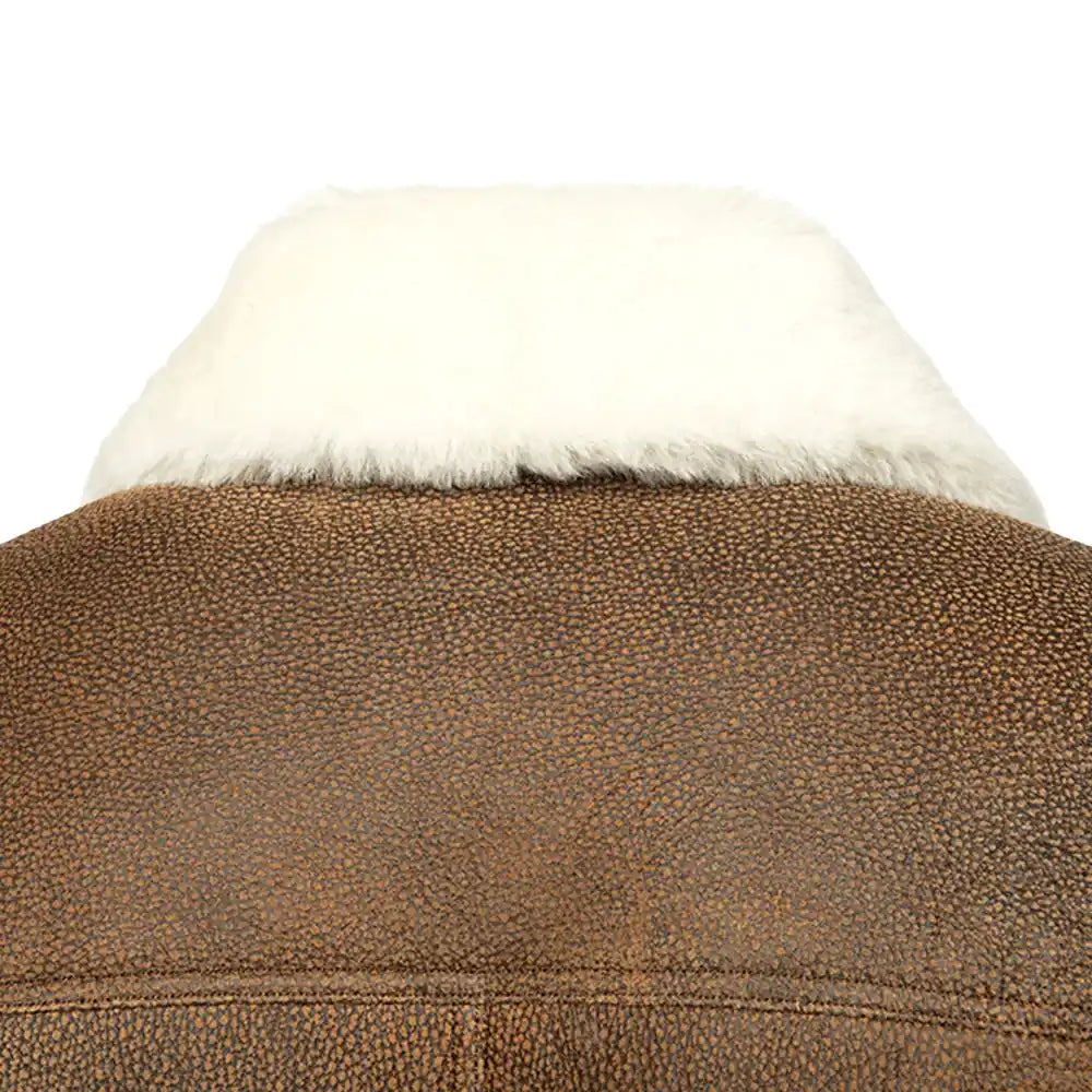 Close-up of the luxurious double-faced sheepskin leather texture of a Jacoba brown bomber jacket, featuring soft suede and smooth leather with a rugged finish.