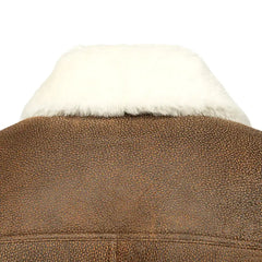 Close-up of the luxurious double-faced sheepskin leather texture of a Jacoba brown bomber jacket, featuring soft suede and smooth leather with a rugged finish.