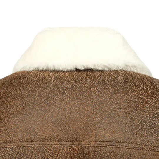 Close-up of the luxurious double-faced sheepskin leather texture of a Jacoba brown bomber jacket, featuring soft suede and smooth leather with a rugged finish.