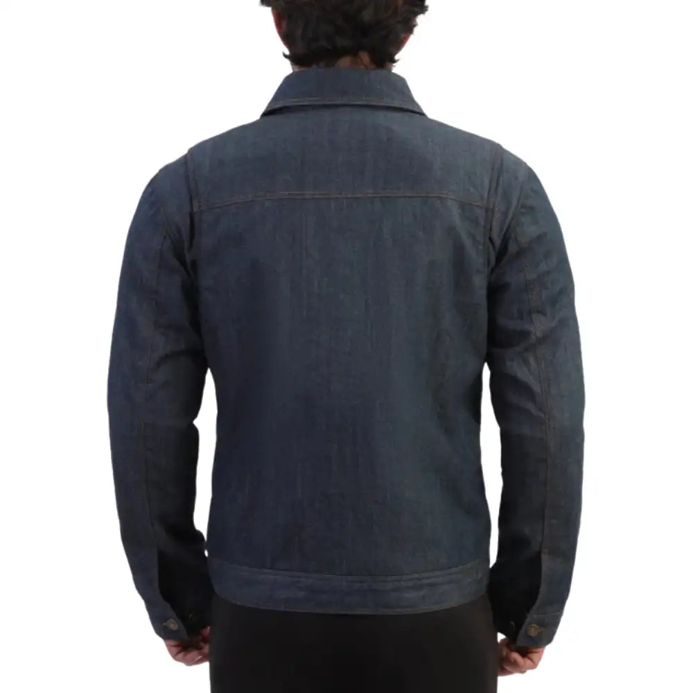 A back view of the male model wearing the Julian armored blue denim leather motorcycle jacket, paired with riding jeans and boots, standing in a confident three-quarter pose.