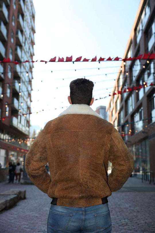 Person back pose by wearing Lucian's distressed brown A2 Bomber shearling jacket with white fur lining in an urban setting.