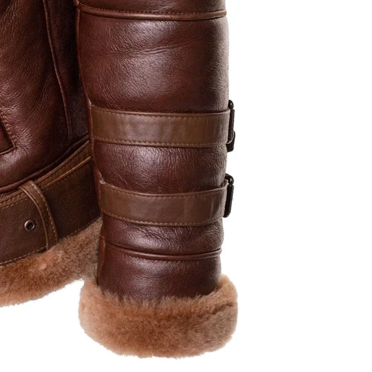 Detailed view of the adjustable wrist belt cuffs and shearling trim on Phan's brown leather aviator bomber jacket.