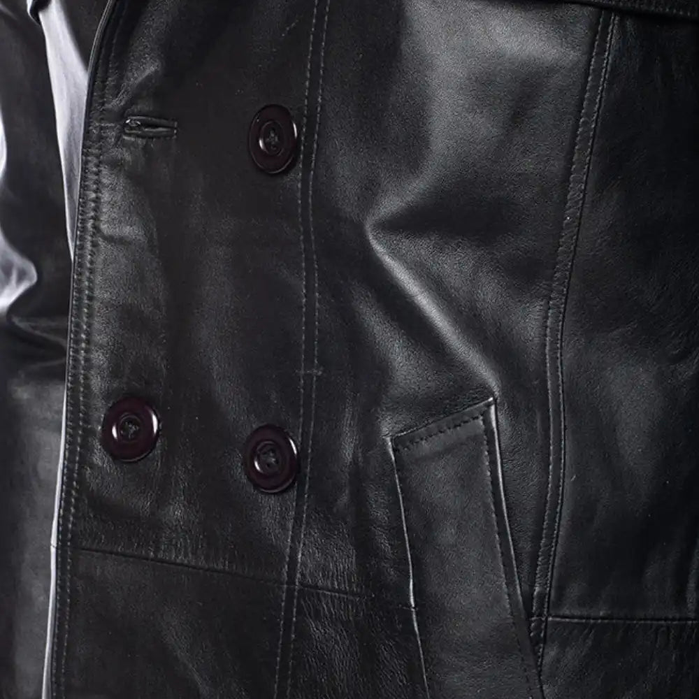 Close-up of a black leather coat with buttons and a pocket.