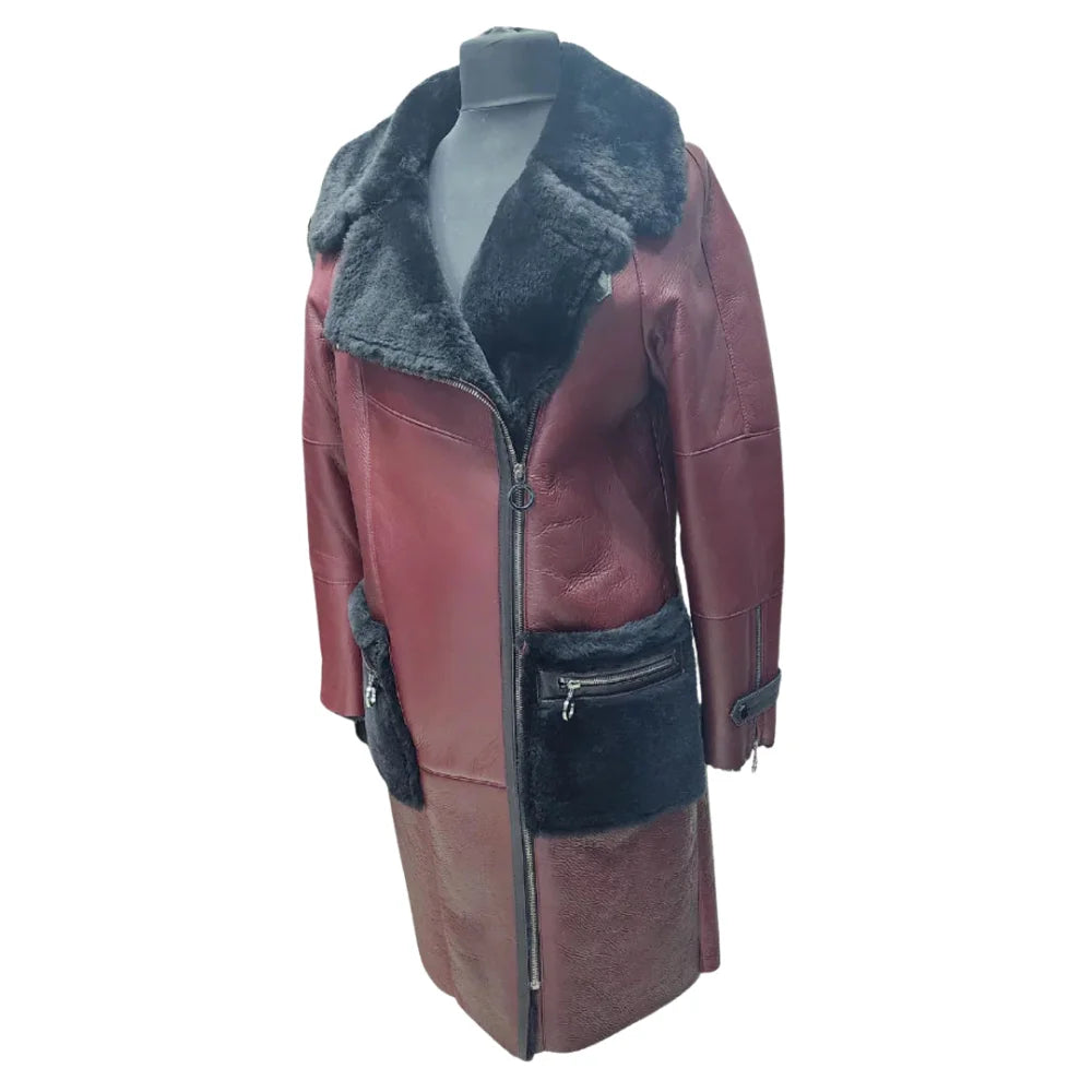 A 3/4 side profile of the burgundy shearling trench coat on a mannequin, highlighting the depth of the fur-lined pockets and the zippered sleeve detail.