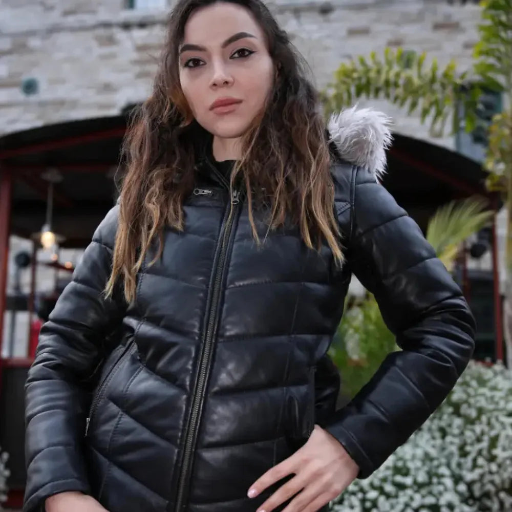 A model wearing the Snow’s hooded leather puffer in a winter setting, demonstrating the jacket’s warmth, volume, and protective fit.