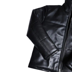 Close-up of the Sorine jacket’s premium black leather, highlighting the soft sheen, fine stitching, and concealed zipper pockets.